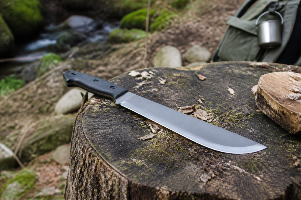Machete på trädstubbe i naturlig outdoormiljö